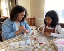 Family members making their own lip gloss together with a DIY Kit Creations Lip Gloss Making Kit